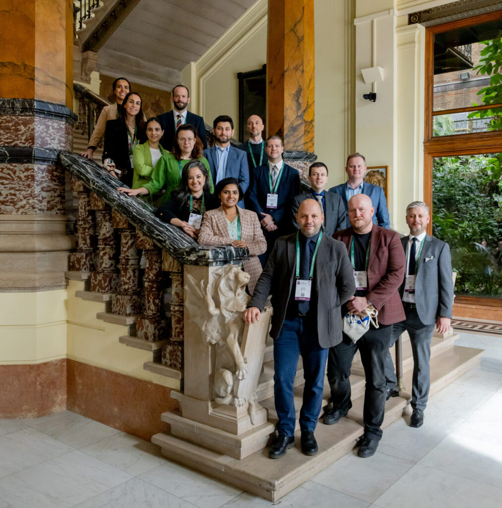 Young female medical professional in blue scrubs smiling in a hospital setting.